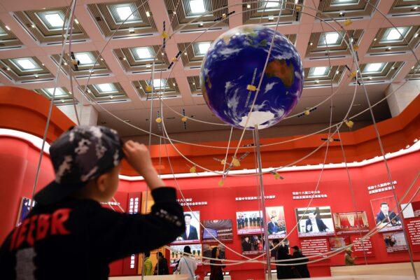 A boy looks at the BeiDou Satellite Navigation System at an exhibition marking the 40th anniversary of China's reform and opening up at the National Museum of China in Beijing on Feb. 27, 2019. (WANG ZHAO/AFP via Getty Images)
