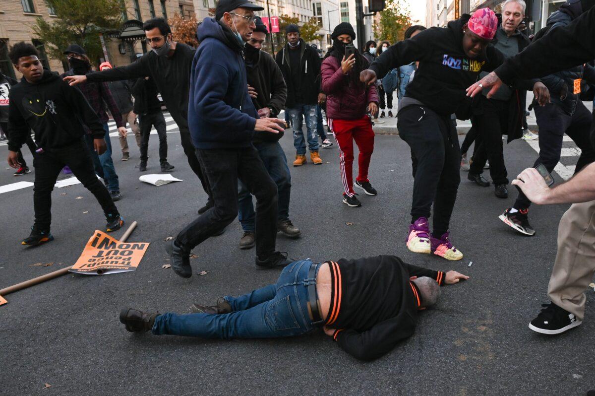 A person later identified as Alexus Doris Owens stomps on the head of a President Donald Trump supporter who was sucker punched, in Black Lives Matter Plaza in Washington on Nov. 14, 2020. (Roberto Schmidt/AFP via Getty Images)