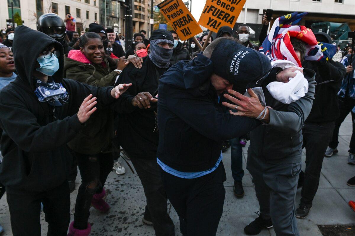 A supporter of President Donald Trump is attacked by anti-Trump demonstrators in Black Lives Matter Plaza in Washington on Nov. 14, 2020. (Roberto Schmidt/AFP via Getty Images)