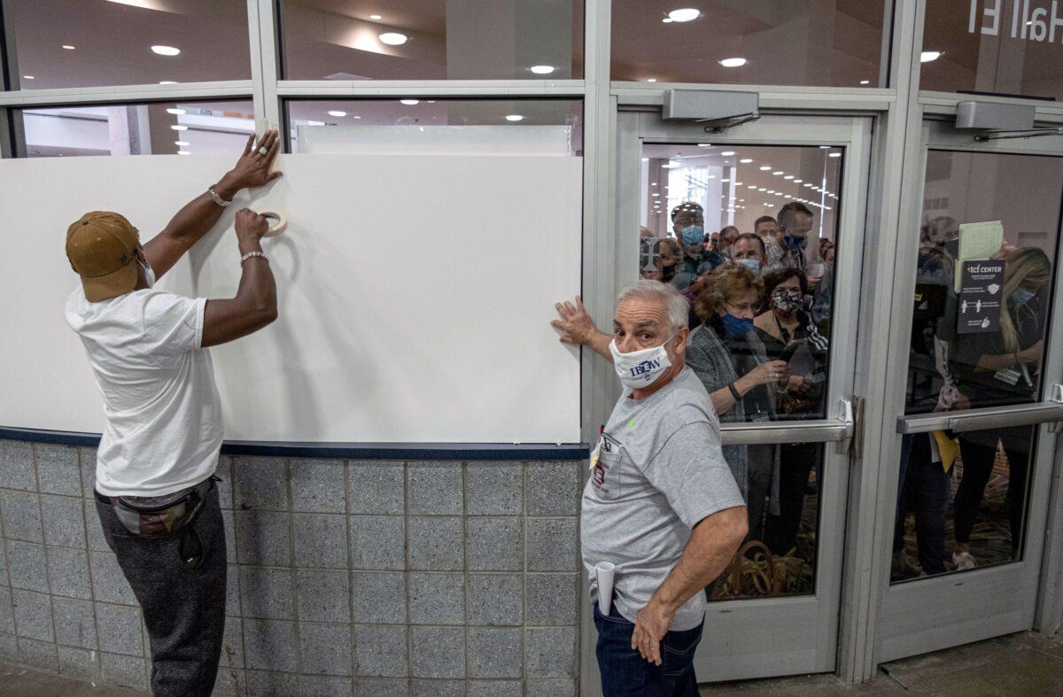 Poll workers board up windows so ballot challengers can't see into the ballot counting area at the TCF Center where ballots are being counted in downtown Detroit on Nov. 4,2020. (Seth Herald/AFP via Getty Images)