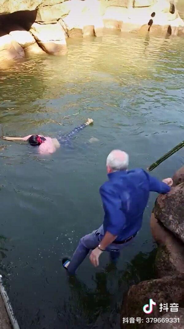 In this screengrab taken from a social media video, Stephen Ellison, British consul-general in Chongqing, leaps into a river to rescue a drowning student at a scenic spot in Chongqing, China, on Nov. 14, 2020. (Zhu Dafen via Reuters)
