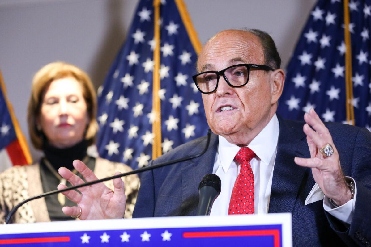 Trump lawyer and former New York City Mayor Rudy Giuliani speaks to media as Trump campaign lawyer Sidney Powell looks on during a press conference at the Republican National Committee headquarters in Washington on Nov 19, 2020. (Charlotte Cuthbertson/The Epoch Times)