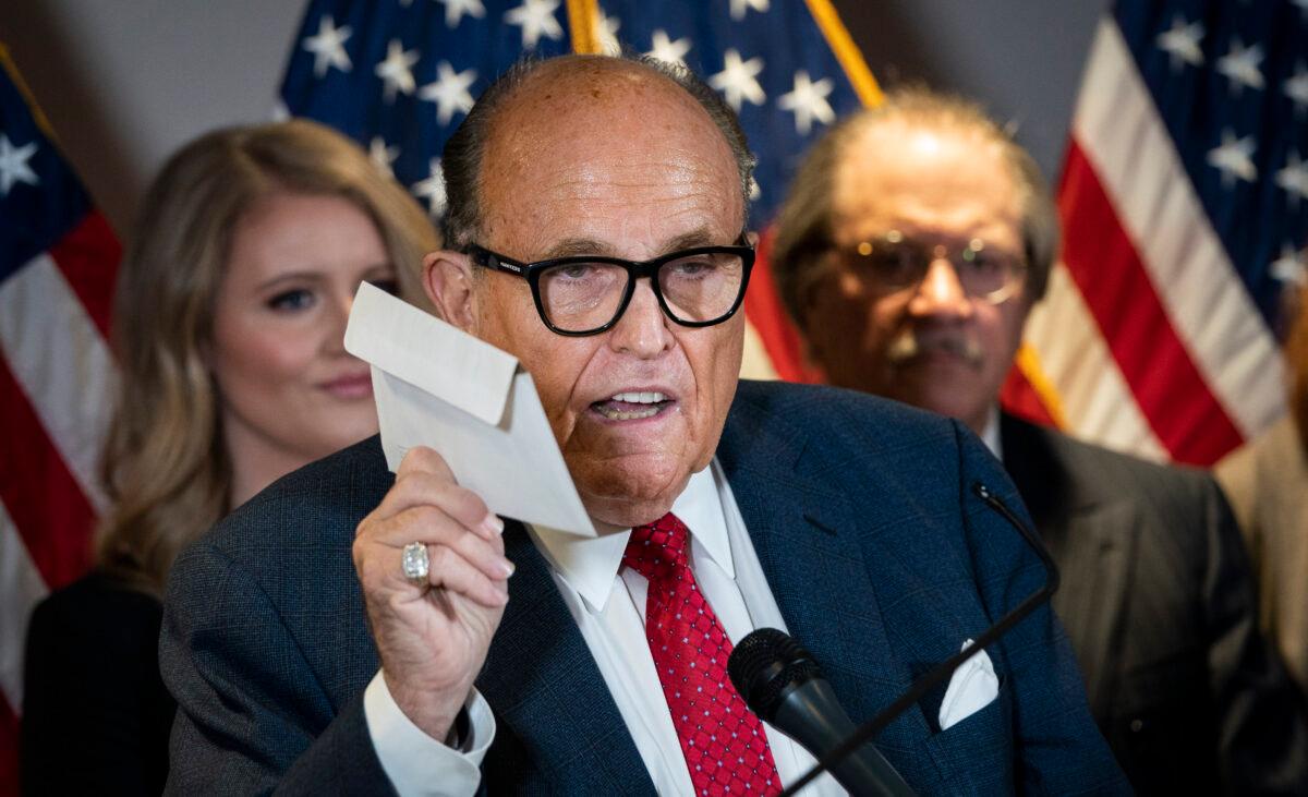 Rudy Giuliani holds up a mail-in ballot as he speaks to the press about various lawsuits related to the 2020 election, inside the Republican National Committee headquarters in Washington, on Nov. 19, 2020. (Drew Angerer/Getty Images)