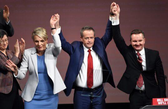 Bill Shorten (C), raises his hands with Tanya Plibersek (L) and Chris Bowen (R) at an election event in Sydney on June 19, 2016.(William West/AFP via Getty Images)