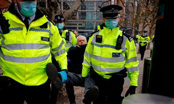 Police officers take away a man ahead of an anti-lockdown protest against government restrictions designed to control or mitigate the spread of the CCP virus, including the wearing of masks and lockdowns, at Kings Cross station in London, on Nov. 28, 2020. (Tolga Akmen/AFP via Getty Images)