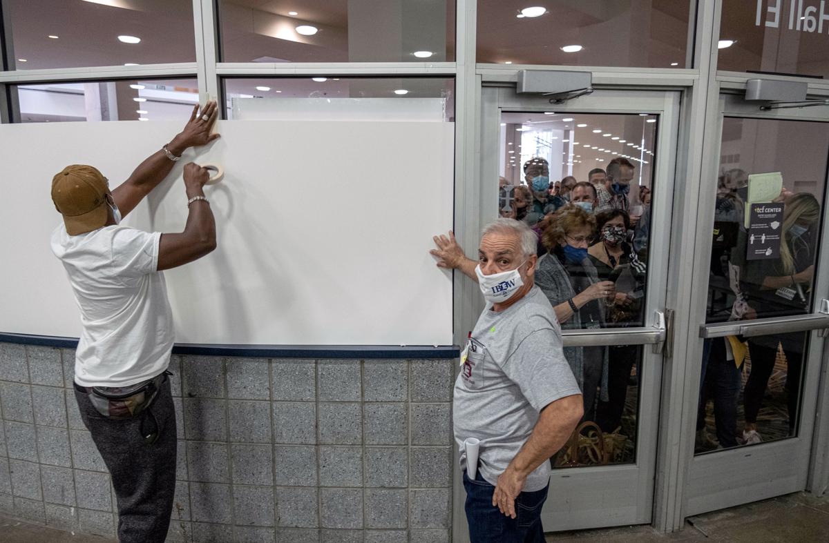 Poll workers board up windows so ballot challengers can't see into the ballot counting area at the TCF Center, in downtown Detroit, on Nov. 4, 2020. (Seth Herald/AFP via Getty Images)