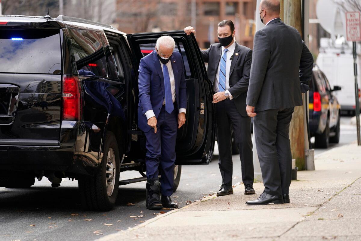 Democratic presidential nominee Joe Biden points to the walking boot he's wearing as he arrives at the Queen Theater in Wilmington, Del., on Dec. 1, 2020. (Andrew Harnik/AP Photo)