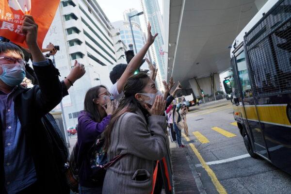Supporters react next to a police van after the sentencing of pro-democracy activists Joshua Wong, Agnes Chow and Ivan Lam, at West Kowloon Magistrates' Courts in Hong Kong, Dec. 2, 2020. (Lam Yik/Reuters)