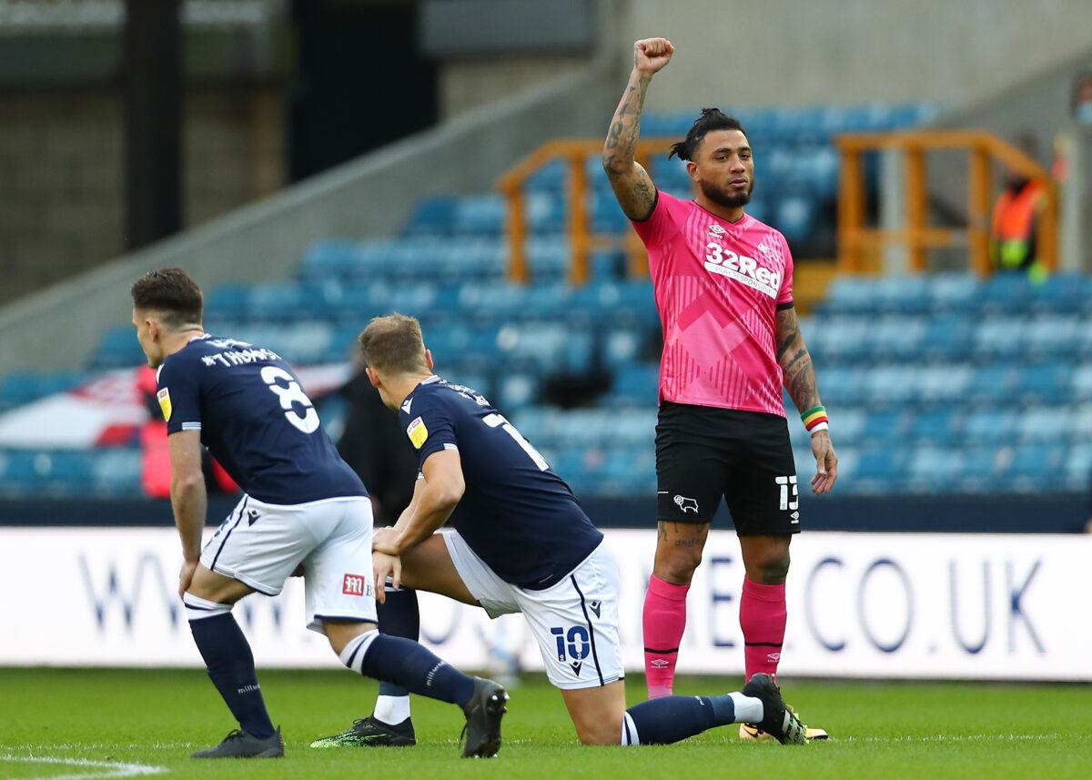 Colin Kazim-Richards of Derby County raises his right fist—a symbol of Black Lives Matter—as other players take the knee ahead of the match between Millwall and Derby County at The Den in London, on Dec. 05, 2020. (Jacques Feeney/Getty Images)