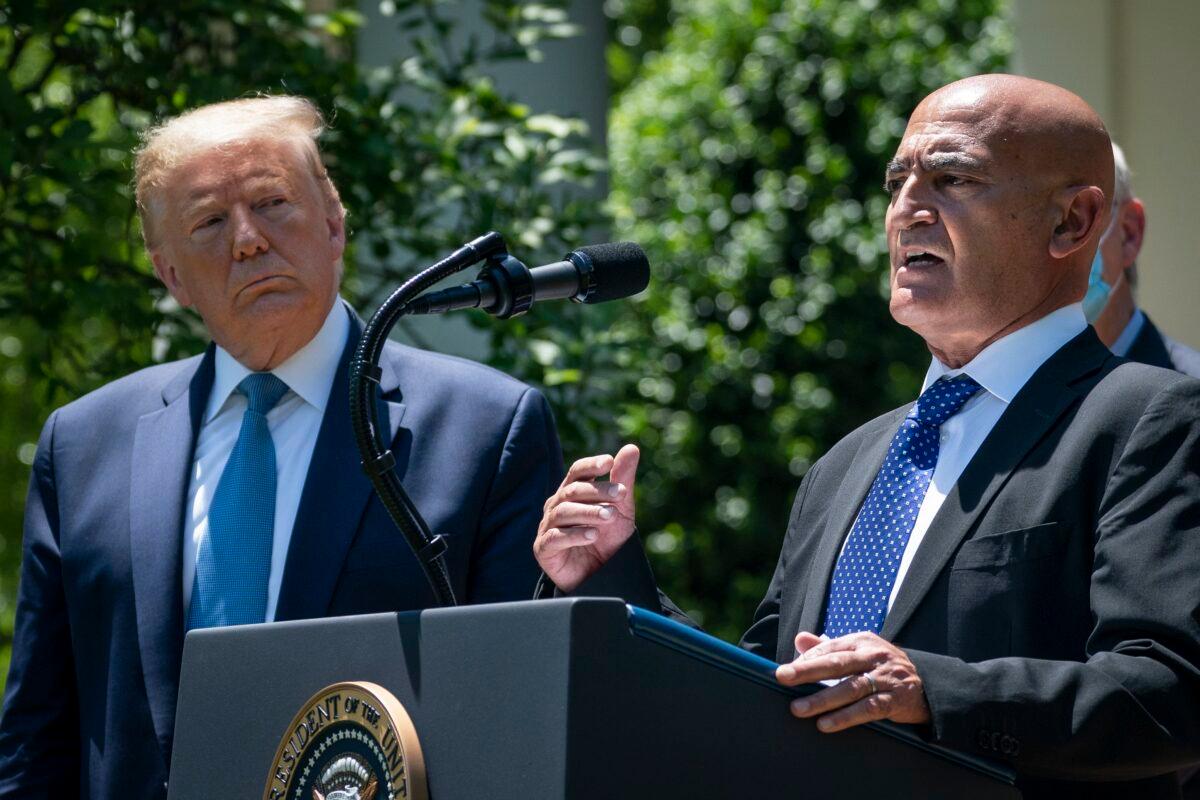 President Donald Trump listens as Moncef Slaoui, chief adviser for Operation Warp Speed, speaks in Washington on May 15, 2020. (Drew Angerer/Getty Images)