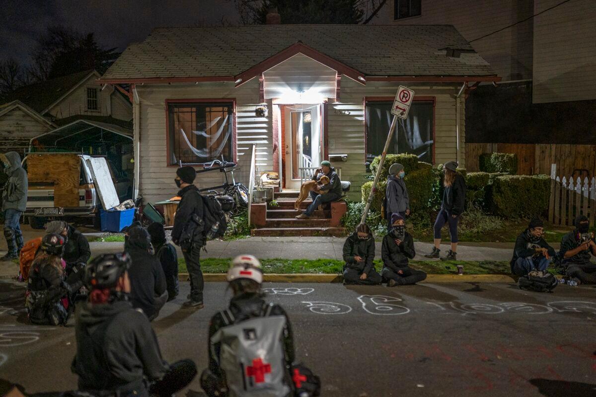 People gather outside a house where a family was set to be evicted, inside a so-called autonomous zone, in Portland, Ore., on Dec. 9, 2020. (Nathan Howard/Getty Images)