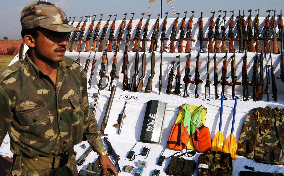 An Indian soldier shows arms recovered from a hideout of the People's Liberation Army near the India–Burma border in Theigotang, India, on Jan. 17, 2005. (STR/AFP via Getty Images)
