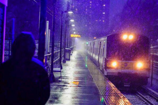 A woman waits for a Long Island Rail Road train during a snow storm as snow starts to fall in the Queens borough of New York on Dec. 16, 2020. (AP Photo/Frank Franklin II)