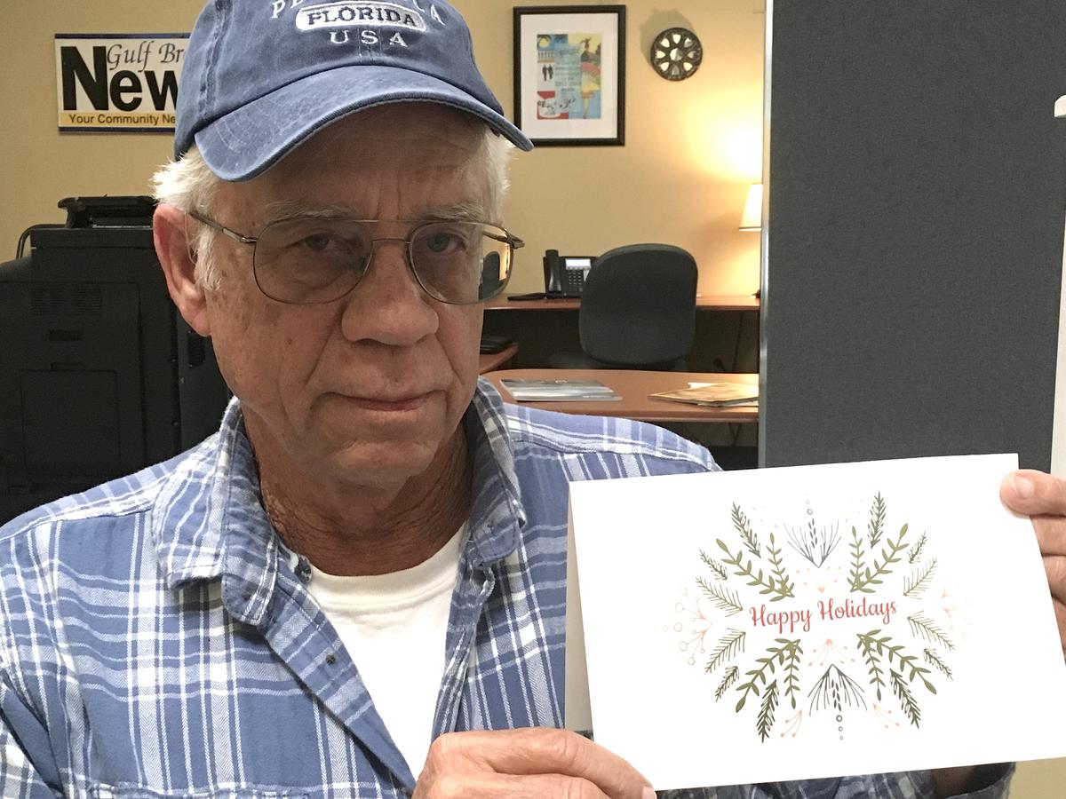 Mike Esmond holding the Christmas card from 2019 that the city sent out. (Courtesy of Gulf Breeze News)