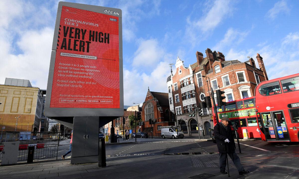 Pedestrians walk past a British government health information advertisement highlighting new restrictions amid the spread of the CCP virus in London on Dec. 19, 2020. (Toby Melville/Reuters)