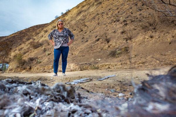 Susan Iwamoto, a resident of Orange County, surveys the fire damage to her property in Williams Canyon, Calif., on Dec. 23, 2020. (John Fredricks/The Epoch Times)