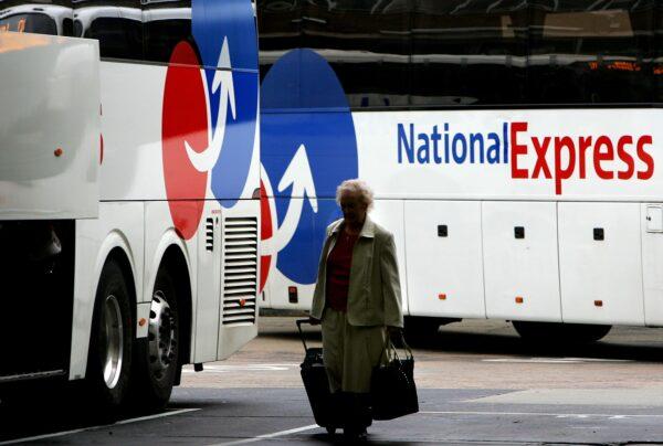 A passenger passes National Express buses due to leave the coach station in London on Aug. 14, 2007. (Cate Gillon/Getty Images)