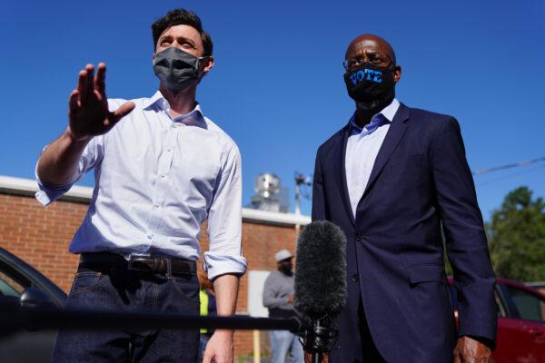 Democratic U.S. Senate candidates Jon Ossoff and Rev. Raphael Warnock hand out lawn signs at a campaign event in Lithonia, Ga., on Oct. 3, 2020. (Elijah Nouvelage/Getty Images)