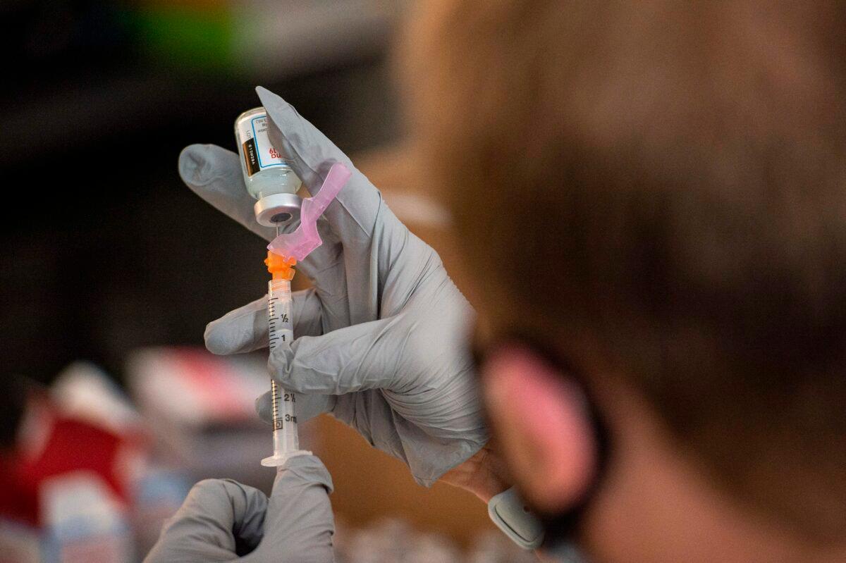 A pharmacist handles COVID-19 vaccine doses in Central Falls, R.I., on Feb. 13, 2021. (Joseph Prezioso/AFP via Getty Images)