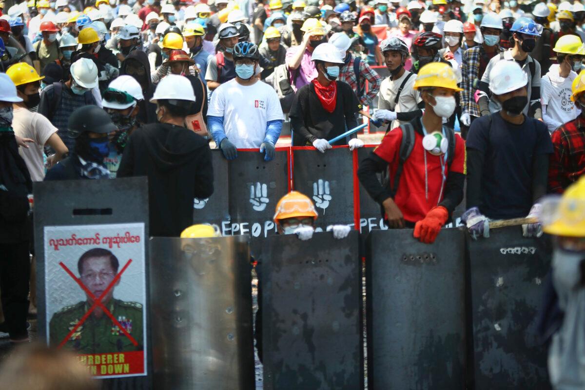 Anti-coup protesters wearing protective gear take positions as police gather in Yangon, Burma, on March 5, 2021. (AP Photo)