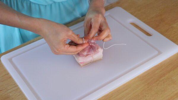 Tie the pork belly pieces with twine. (CiCi Li)
