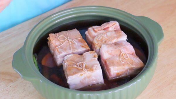 Place the pork belly in the pot, skin side down, and pour over the seasonings. (CiCi Li)
