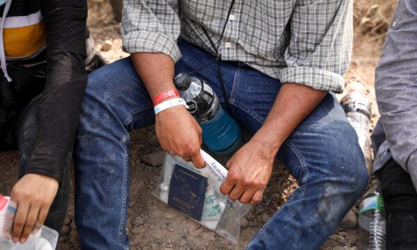 An illegal immigrant wears two wristbands that Mexican cartels have been using to control human smuggling into the United States, near Penitas, Texas, on March 15. 2021. (Charlotte Cuthbertson/The Epoch Times)