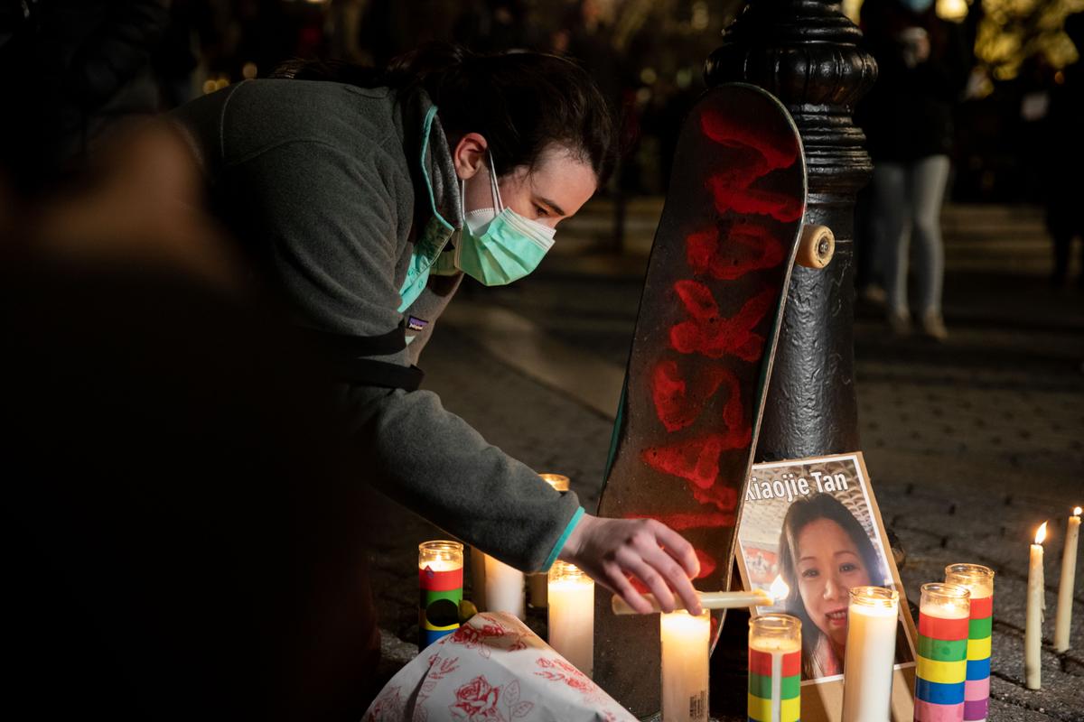 A person lights candles during a vigil for victims of anti-Asian hate crimes at Union Square in New York on March 19, 2021. (Chung I Ho/The Epoch Times)