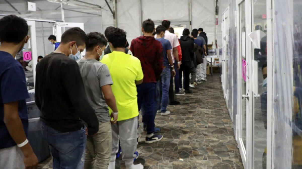 Unaccompanied minors, mostly teen boys, stand in line at a temporary processing facility in Donna, Texas, on March 23, 2021. (CBP)
