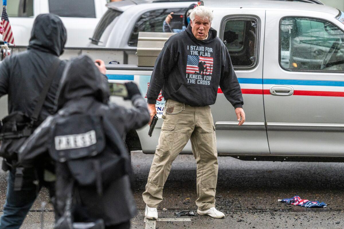 A driver pulls a handgun on Antifa members after they smashed his truck lights, in Salem, Ore., on March 28, 2021. (Nathan Howard/Getty Images)
