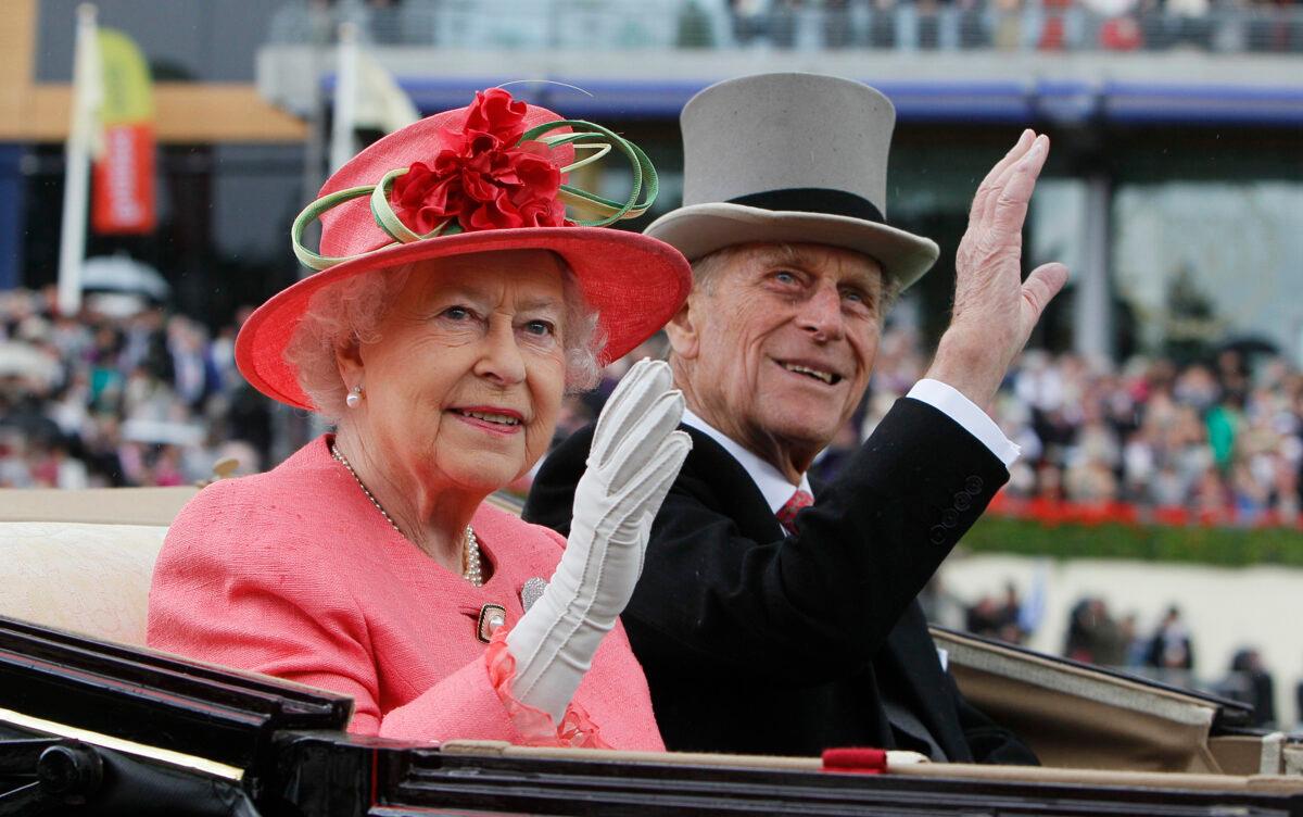 Britain’s Queen Elizabeth II and Prince Philip arrive by horse-drawn carriage in the parade ring on the third day, traditionally known as Ladies Day, of the Royal Ascot horse race meeting at Ascot, England, on June 16, 2011. (Alastair Grant/AP Photo)