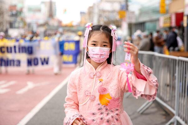A young Falun Gong practitioner takes part in a parade in Flushing, New York, on April 18, 2021, to commemorate the 22nd anniversary of the April 25th peaceful appeal of 10,000 Falun Gong practitioners in Beijing. (Samira Bouaou/The Epoch Times)