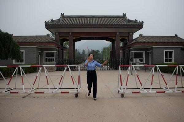 A policewoman attempts to stop the taking of photos at the entrance to Qincheng prison on the outskirts of Beijing on Sept. 12, 2013. (Ed Jones/AFP via Getty Images)