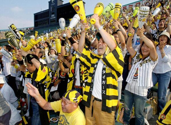Fans of Hanshin Tigers celebrate as the team clinched their first league championship in 18 years at the Koshien Stadium in Nishinomiya, near Osaka, Japan, on Sept. 15, 2003. (STR/AFP via Getty Images)