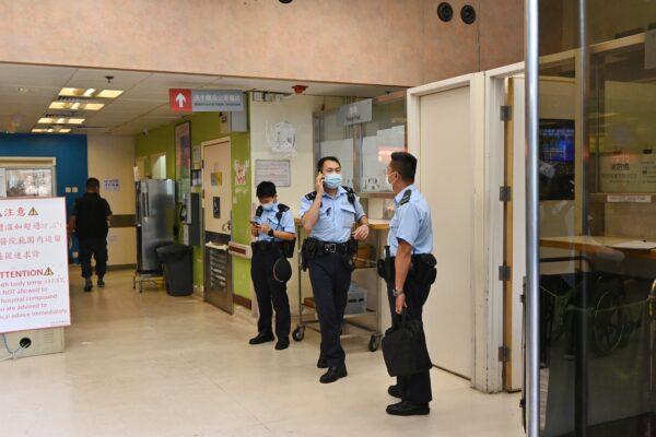 Hong Kong police officers arrive at the Queen Elizabeth Hospital in Hong Kong on May 11, 2021. (Song Pi-lung/The Epoch Times)