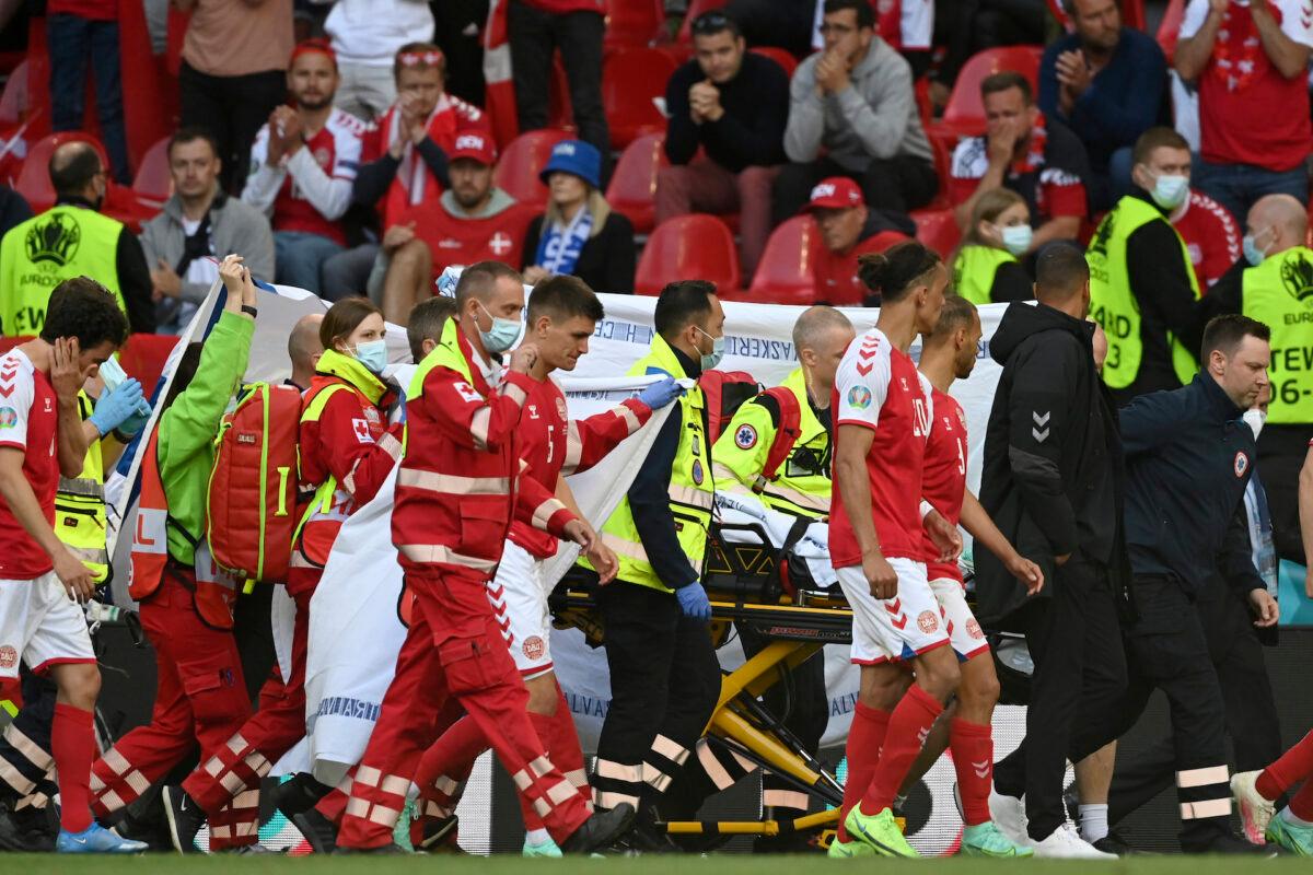 Denmark's Christian Eriksen is taken away on a stretcher after collapsing on the pitch during the Euro 2020 soccer championship group B match between Denmark and Finland at Parken Stadium in Copenhagen, on June 12, 2021. (Stuart Franklin/Pool via AP)