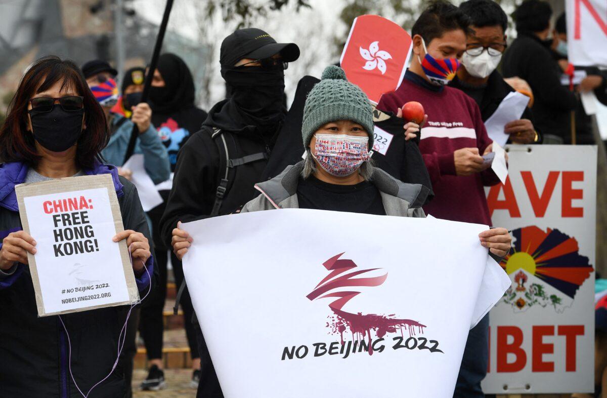 Activists including members of the local Hong Kong, Tibetan, and Uyghur communities hold up banners and placards in Melbourne, Australia, on June 23, 2021, calling on the Australian government to boycott the 2022 Beijing Winter Olympics over China's human rights record. (William West/AFP via Getty Images)