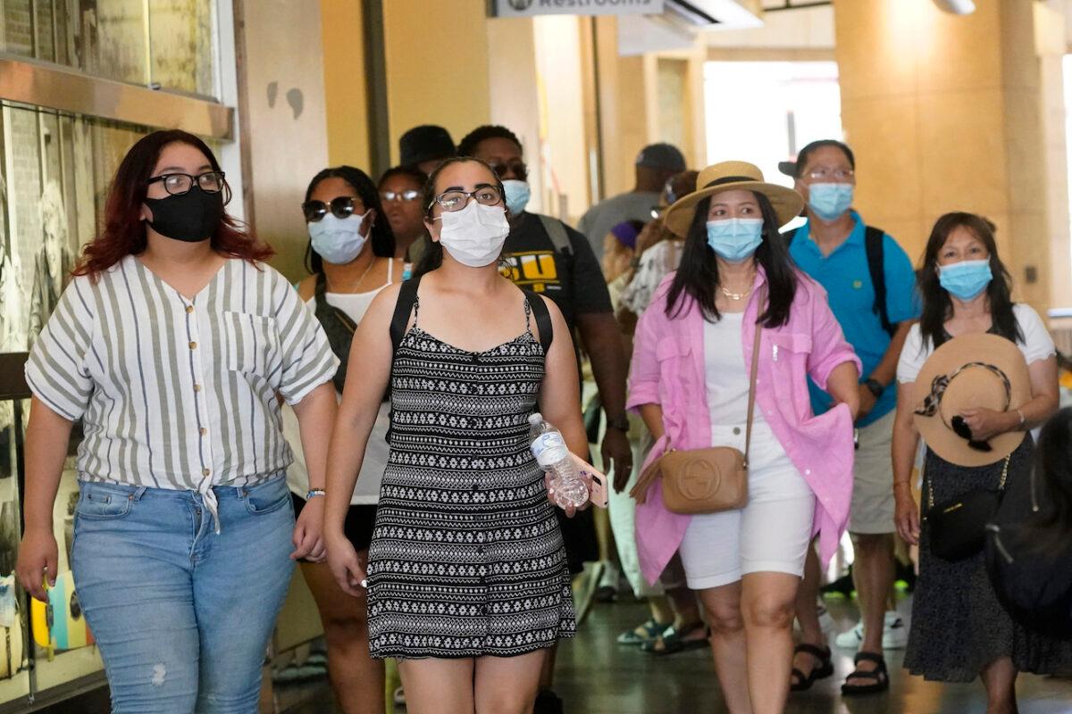 People wear masks as they walk in a shopping district in the Hollywood section of Los Angeles on July 1, 2021. (Marcio Jose Sanchez/AP Photo)