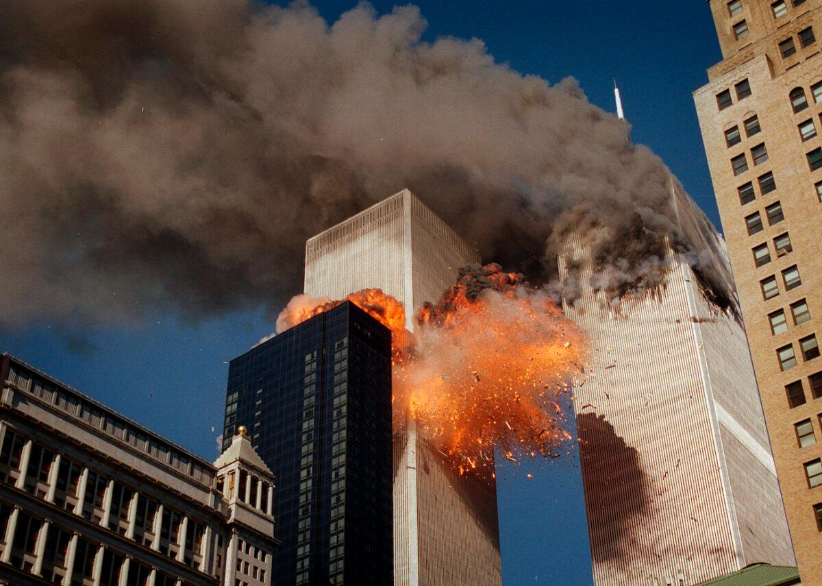 Smoke billows from one of the towers of the World Trade Center as flames and debris explode from the second tower, in New York City, on Sept. 11, 2001. (Chao Soi Cheong/AP Photo)