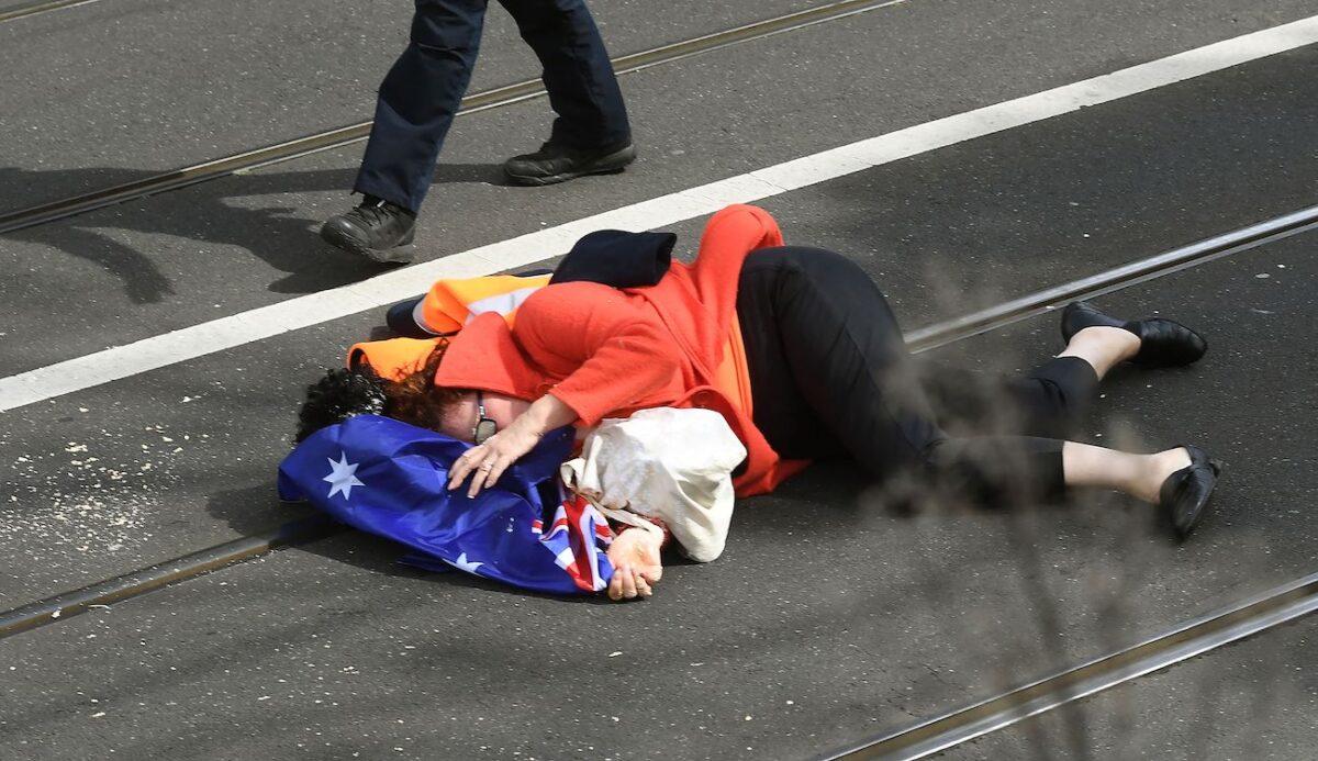 A female protester was pushed to the ground and attacked with pepper spray to her face by police officers, during a Freedom rally in Melbourne on Sept. 18, 2021. (William West/AFP via Getty Images)