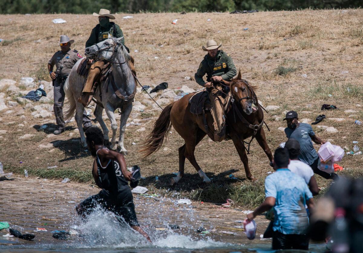 U.S. Customs and Border Protection mounted officers attempt to contain illegal migrants as they cross the Rio Grande from Ciudad Acuña, Mexico, into Del Rio, Texas, Sunday, Sept. 19, 2021. (Felix Marquez/AP Photo)