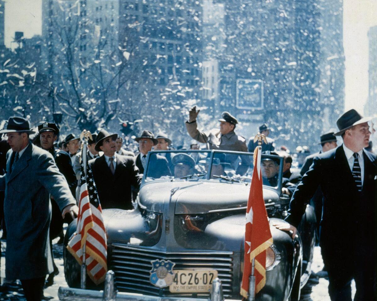 General Douglas MacArthur rides in an open car and waves to well-wishers on April 20, 1951. (Fotosearch/Getty Images)