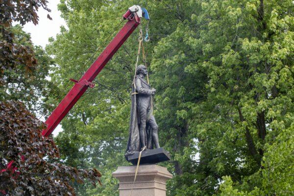 The statue of Canada’s founding prime minister, Sir John A. Macdonald, is removed from a park in his hometown of Kingston, Ont., on June 18, 2021. (The Canadian Press/Lars Hagberg)