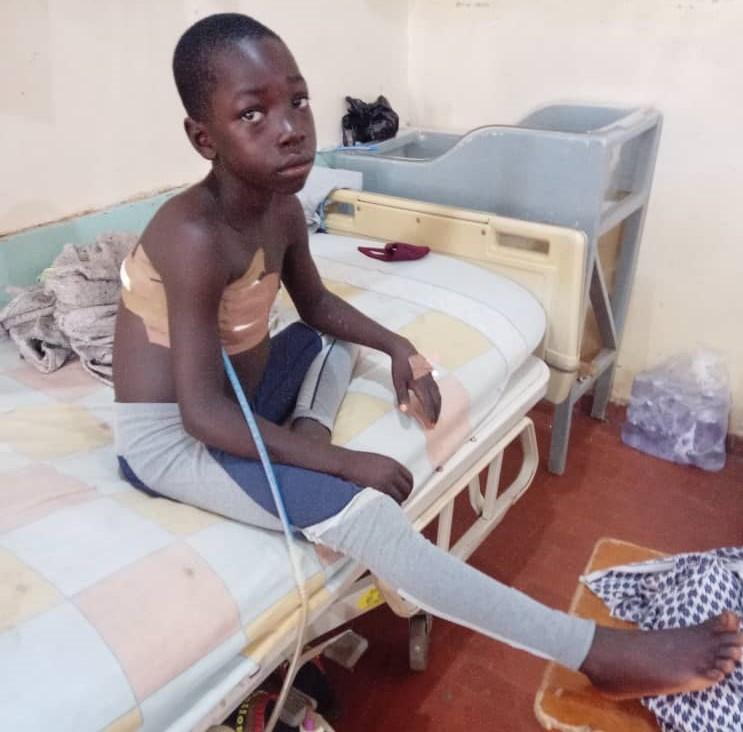 James Ishaya, 11, who survived bullet wounds suffered during the massacre in Madamai, Nigeria, on Sept. 26, 2021, is recuperating in a hospital in Jos, Nigeria on Oct. 1, 2021. (Lawrence Zongo/The Epoch Times)