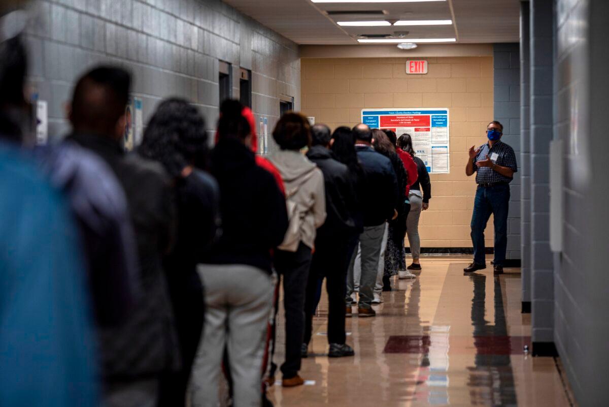 A poll worker talks to a line of voters on election day in Austin, Texas, on Nov. 3, 2020. (Sergio Flores/AFP via Getty Images)