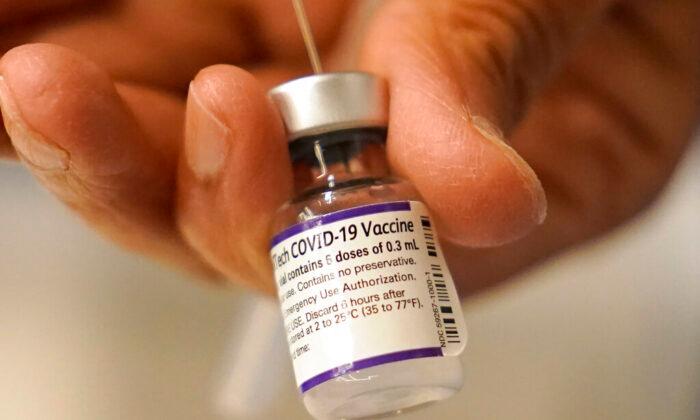 A Pfizer COVID-19 vaccine is transferred into a syringe at a mobile vaccination clinic in Worcester, Mass., on Dec. 2, 2021. (Steven Senne/AP Photo)