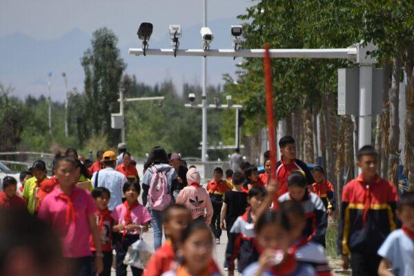 Schoolchildren walking below surveillance cameras in Akto, south of Kashgar, in China's Xinjiang region on June 4, 2019. (Greg Baker/AFP via Getty Images)