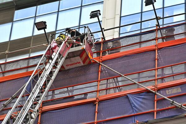 A firefighter rescues a person at the World Trade Center in Hong Kong on Dec. 15, 2021. (Sung Pi-lung/The Epoch Times)
