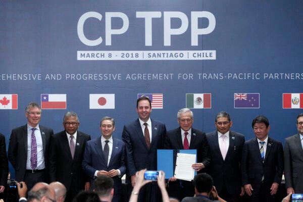 (Left-Right) Trade or foreign ministers of Singapore, New Zealand, Malaysia, Canada, Australia, Chile, Brunei, Japan, Mexico, Peru, and Vietnam pose for an official picture after signing the rebranded 11-nation Pacific trade pact Comprehensive and Progressive Agreement for Trans-Pacific Partnership (CPTPP) in Santiago, on March 8, 2018. (Claudio Reyes/AFP via Getty Images)