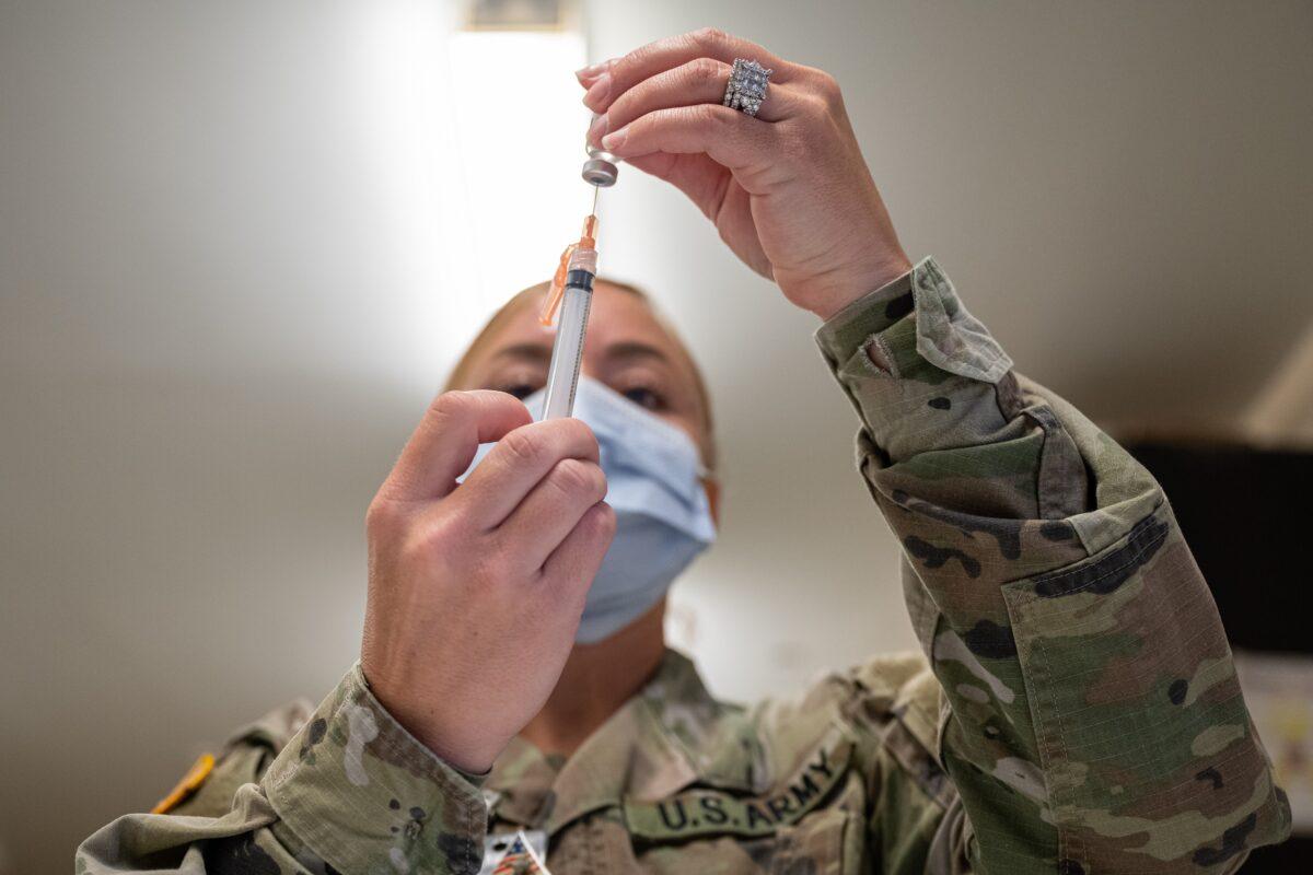 A military member prepares a COVID-19 vaccine in Fort Knox, Ky., on Sept. 9, 2021. (Jon Cherry/Getty Images)